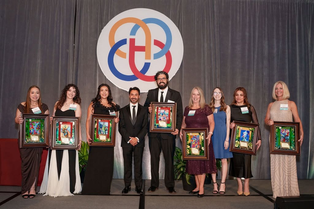 The 2026 West Michigan Hispanic Chamber of Commerce award winners holding their framed certificates on stage